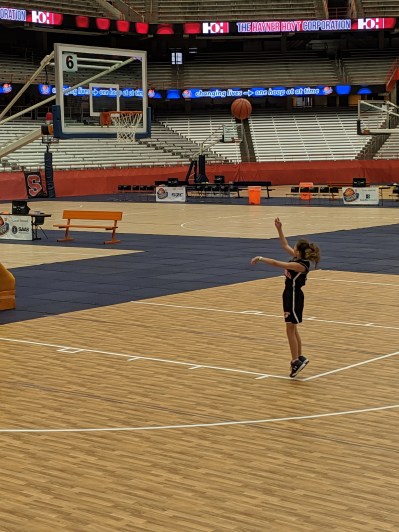 Bean shooting baskets in an empty arena.